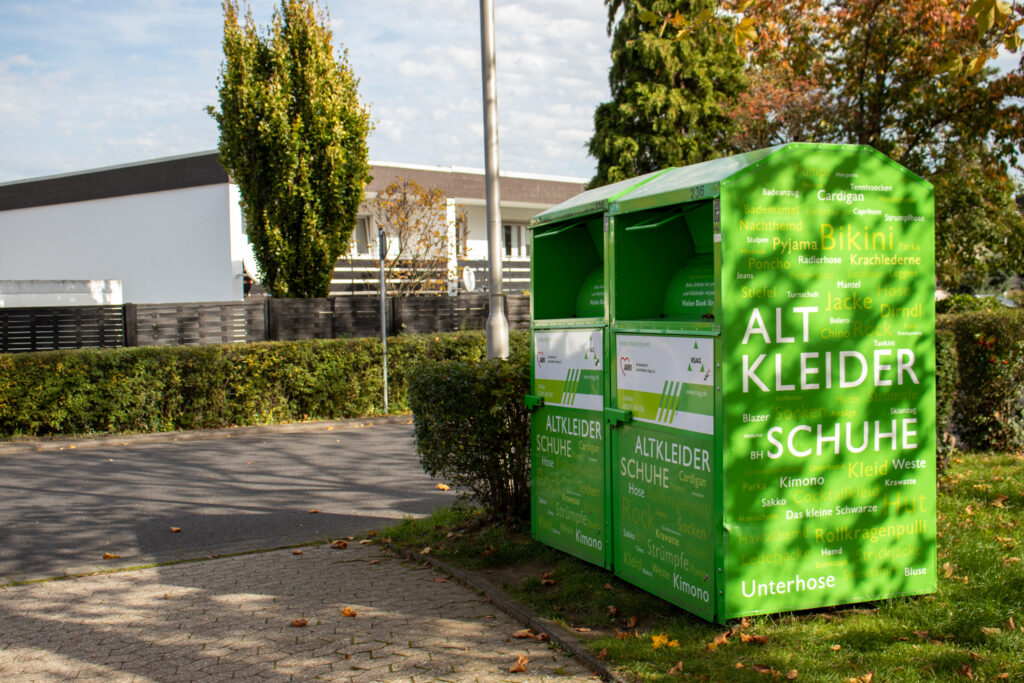 Altkleidercontainer mit Aufschrift für Kleider und Schuhe