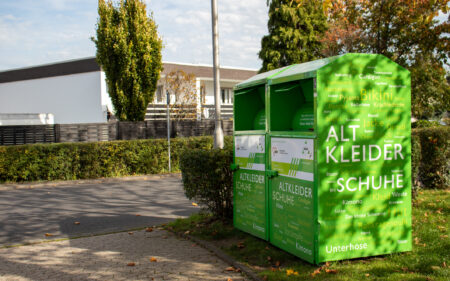 Altkleidercontainer mit Aufschrift für Kleider und Schuhe