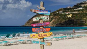 Schilder auf der karibischen Insel St. Maarten: Reisen ist für einige der Weg zum Glück. Foto: Adobe Stock / Reimar