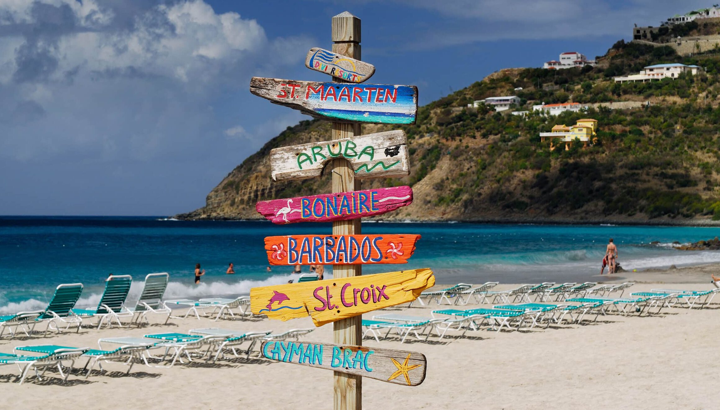 Schilder auf der karibischen Insel St. Maarten: Reisen ist für einige der Weg zum Glück. Foto: Adobe Stock / Reimar